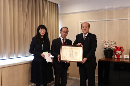 藤田氏と内野市長と最上氏が、贈呈品と感謝状を持っている様子