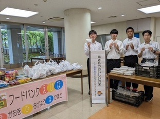 配付する生徒4人がお米を手に持ちカメラ目線で笑顔を浮かべる様子