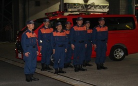 出発する隊員が車両の前で立っている写真