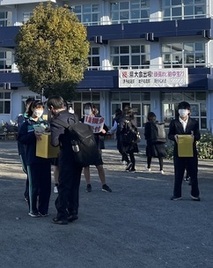 柏ケ谷中学校の校門付近で生徒が募金活動をしている写真